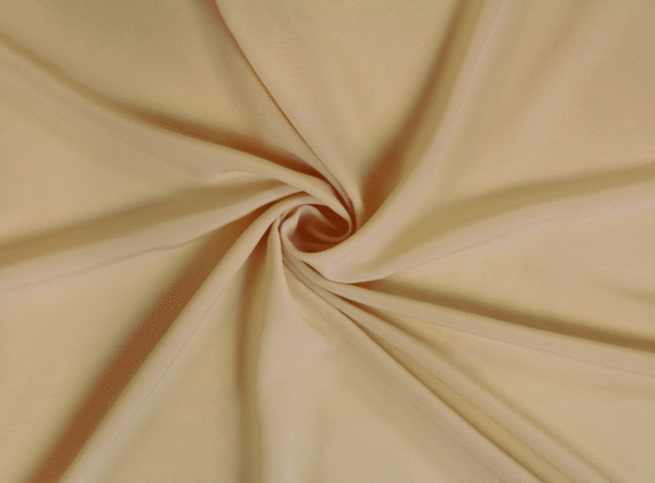 A solid ivory crepe wool dobby fabric twisted into a spiral.