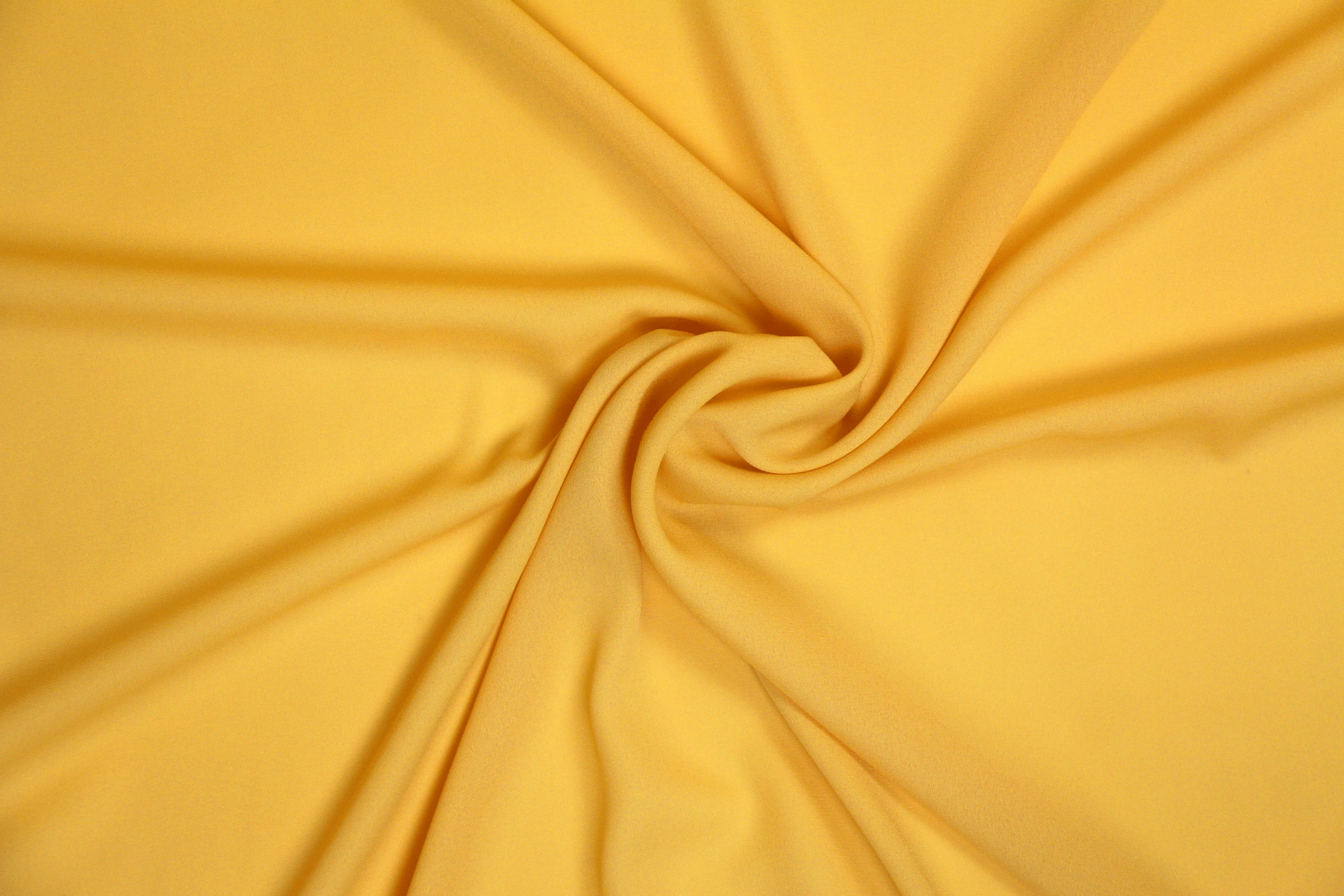 A solid banana yellow georgette fabric twisted into spiral pattern.