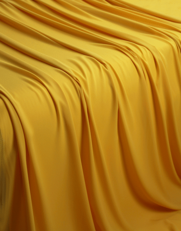 A solid banana yellow georgette fabric flowing off a table in a waterfall pattern.