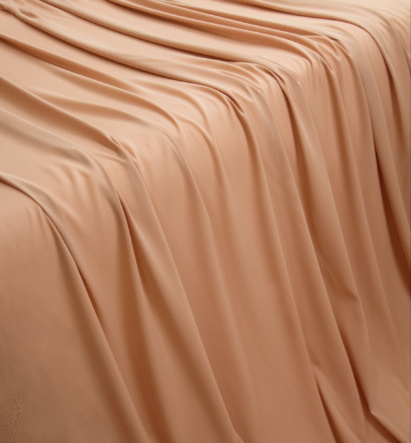 A solid nude georgette fabric flowing over a table making a waterfall pattern.